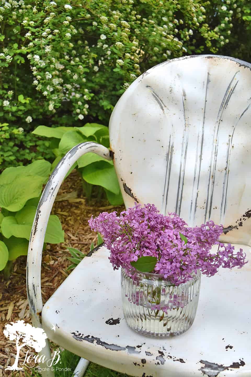 white metal lawn chair with lilacs