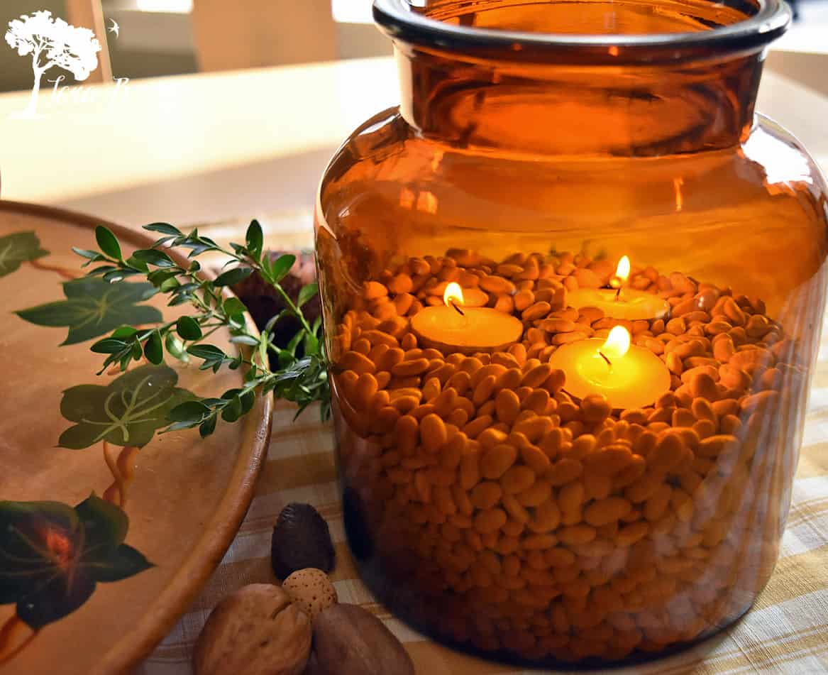 Candlelight glows from inside a brown glass vessel.