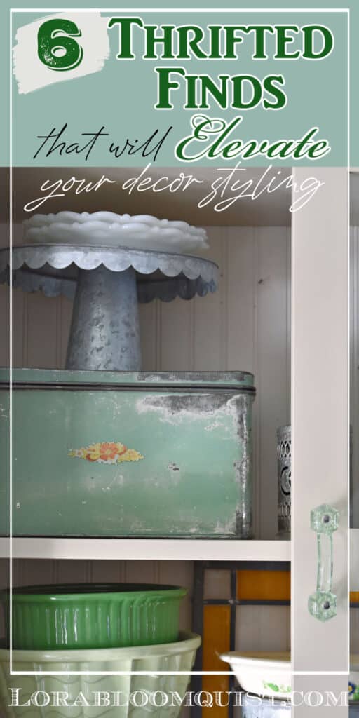 Green metal box and silver cake plate add levels in a kitchen cupboard.