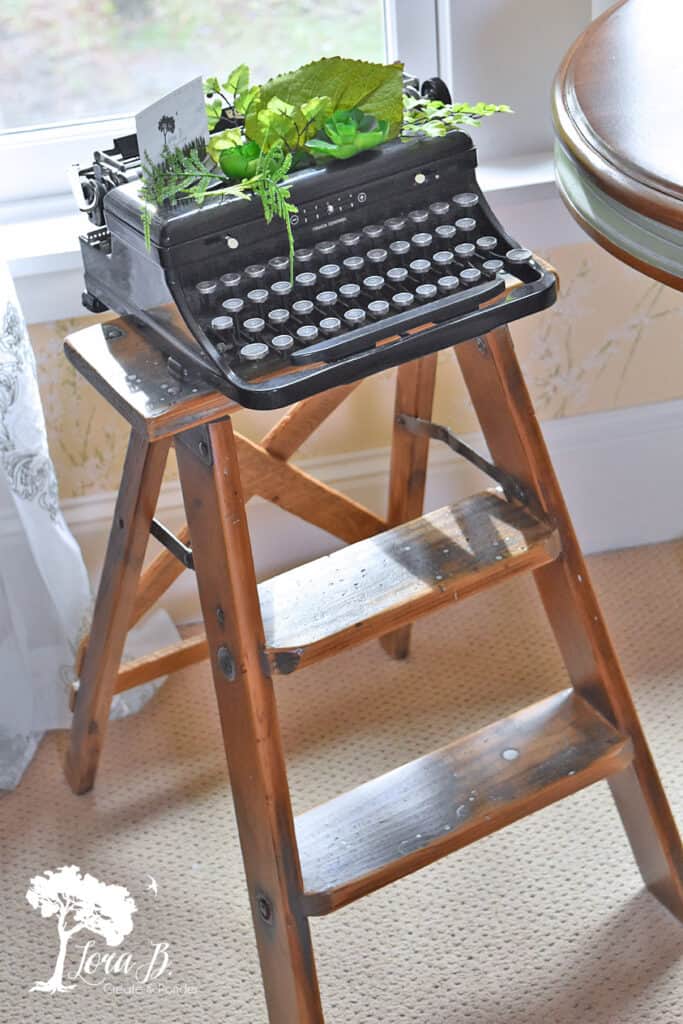 Vintage typewriter displayed on old stepladder.