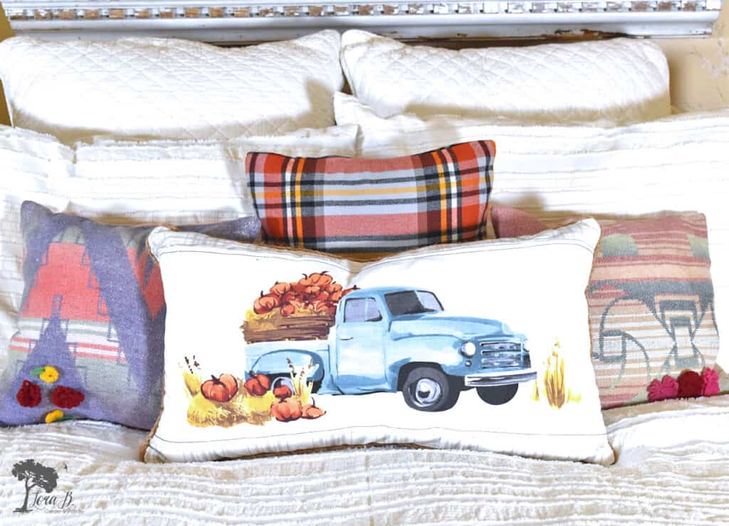 A collection of vintage and new throw pillows add to the charm of this Fall decorated bedroom.