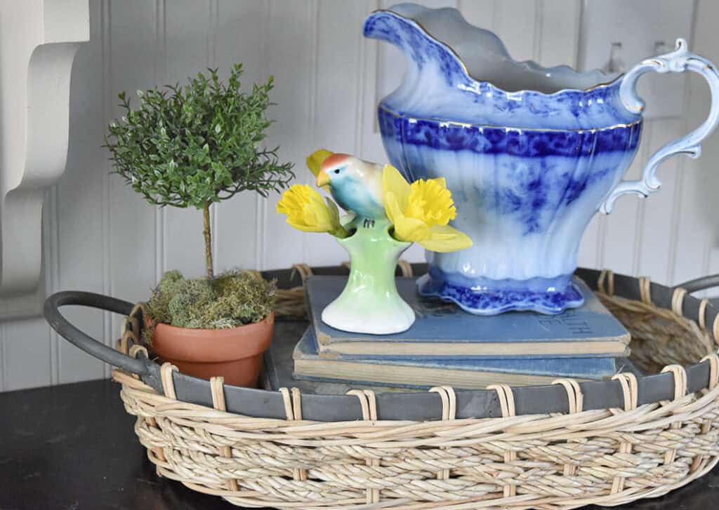 Antique blue china pitcher vignette with bird figurine.