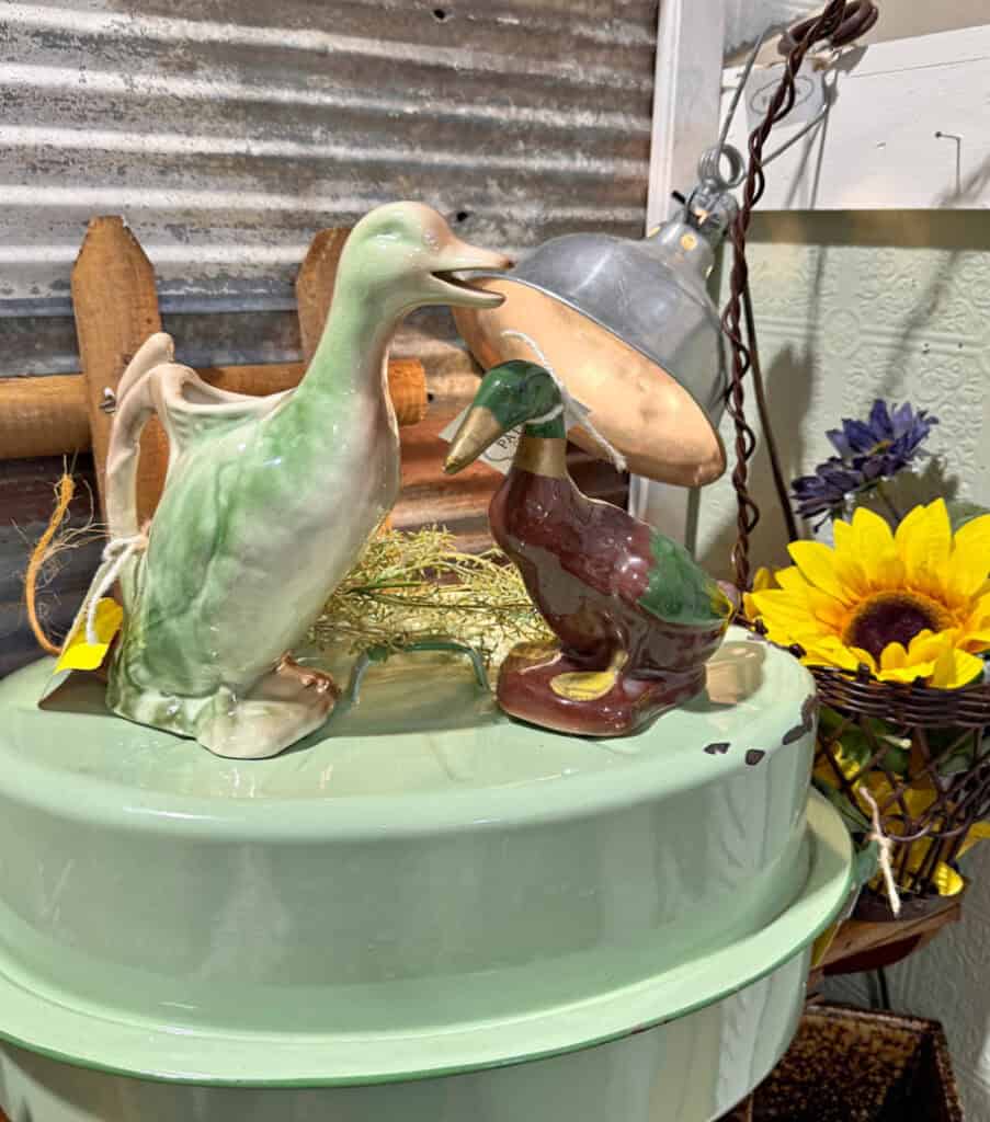 Vintage duck figures on green enamelware stock pan.