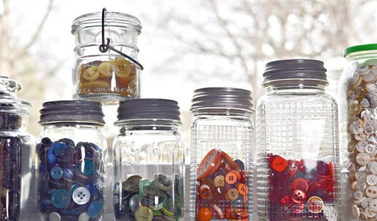 Vintage button collection displayed in glass jars.