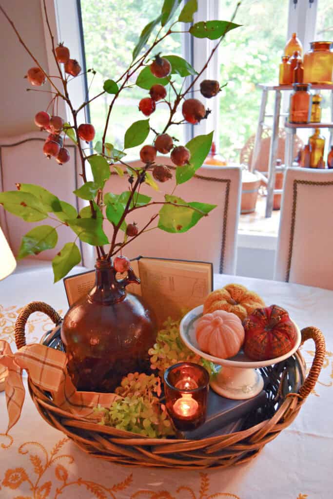 Fall centerpiece vignette with pumpkins and amber glass.