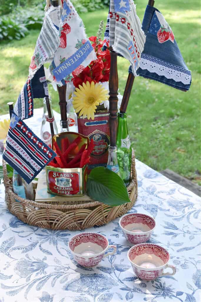 Patriotic centerpiece with scrap fabric flags on table.
