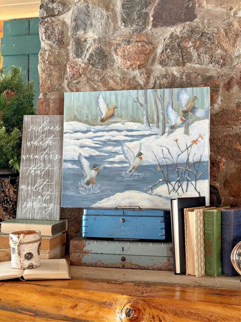 Handpainted duck winter artwork as cabin mantel decor.