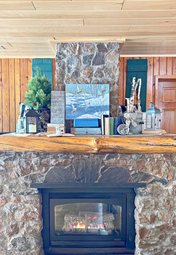 Vintage cabin decor on stone fireplace mantel.