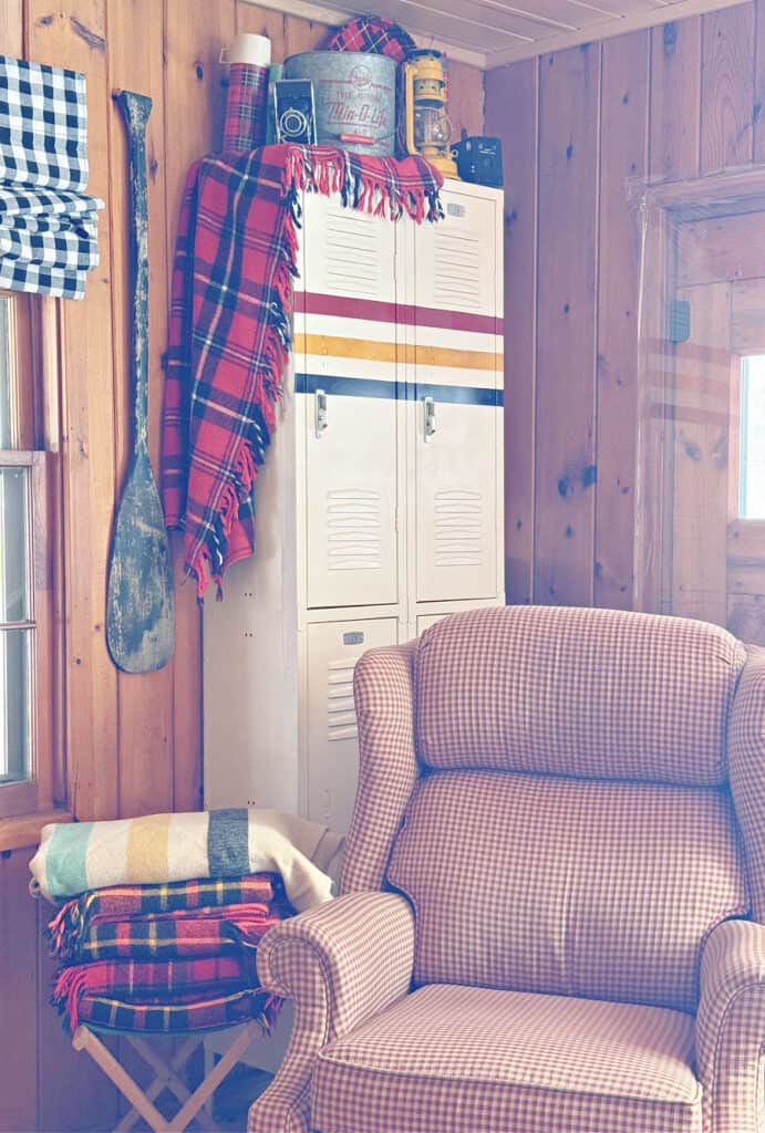 Plaid afghans stacked with vintage finds as cabin decor.