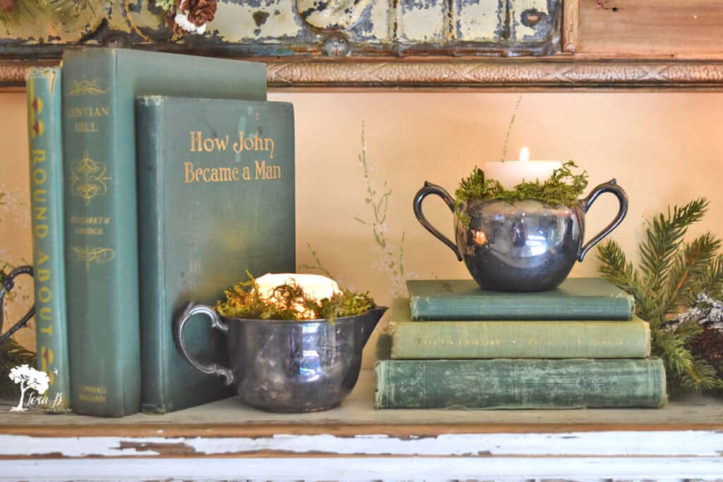 Vintage books and old silver with candles decorate a vintage Christmas decorated bedroom