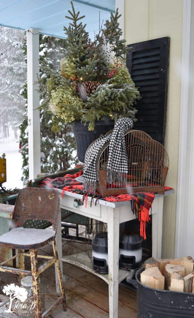 Herringbone old scarf decorating a vintage birdcage as porch decor.