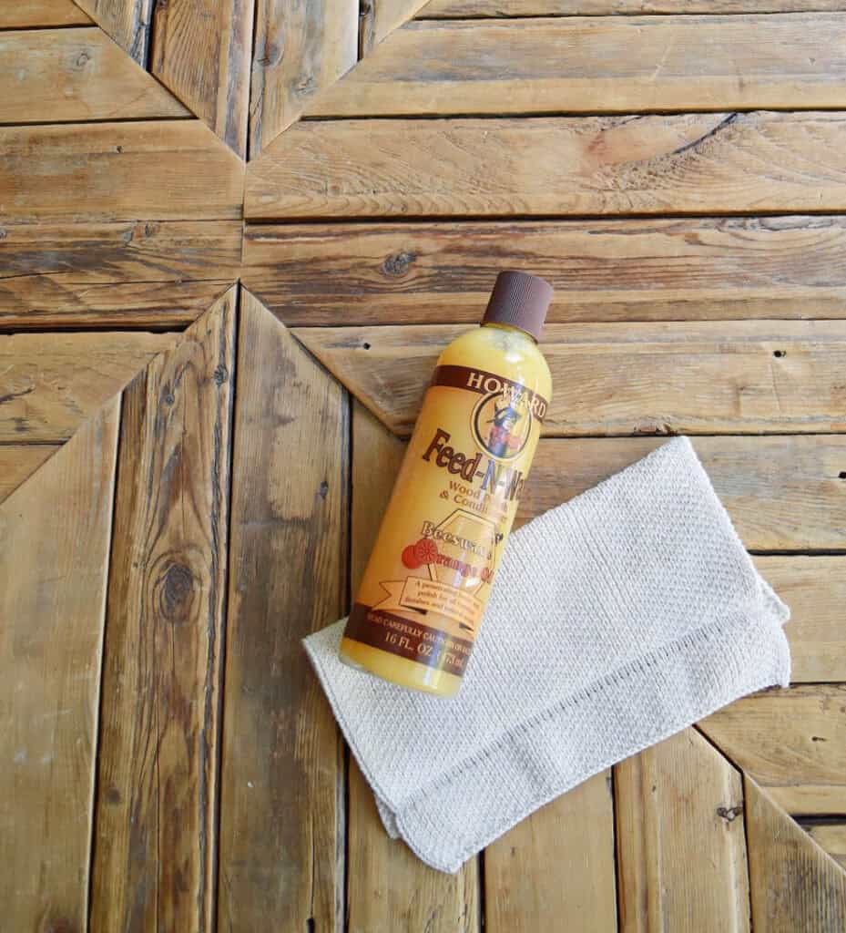 Applying wax to rustic wood coffee table.