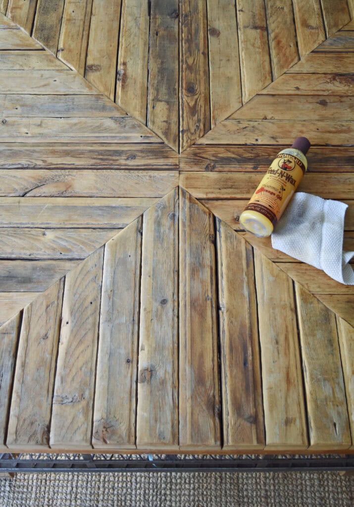 Applying wax to rustic wood coffee table.