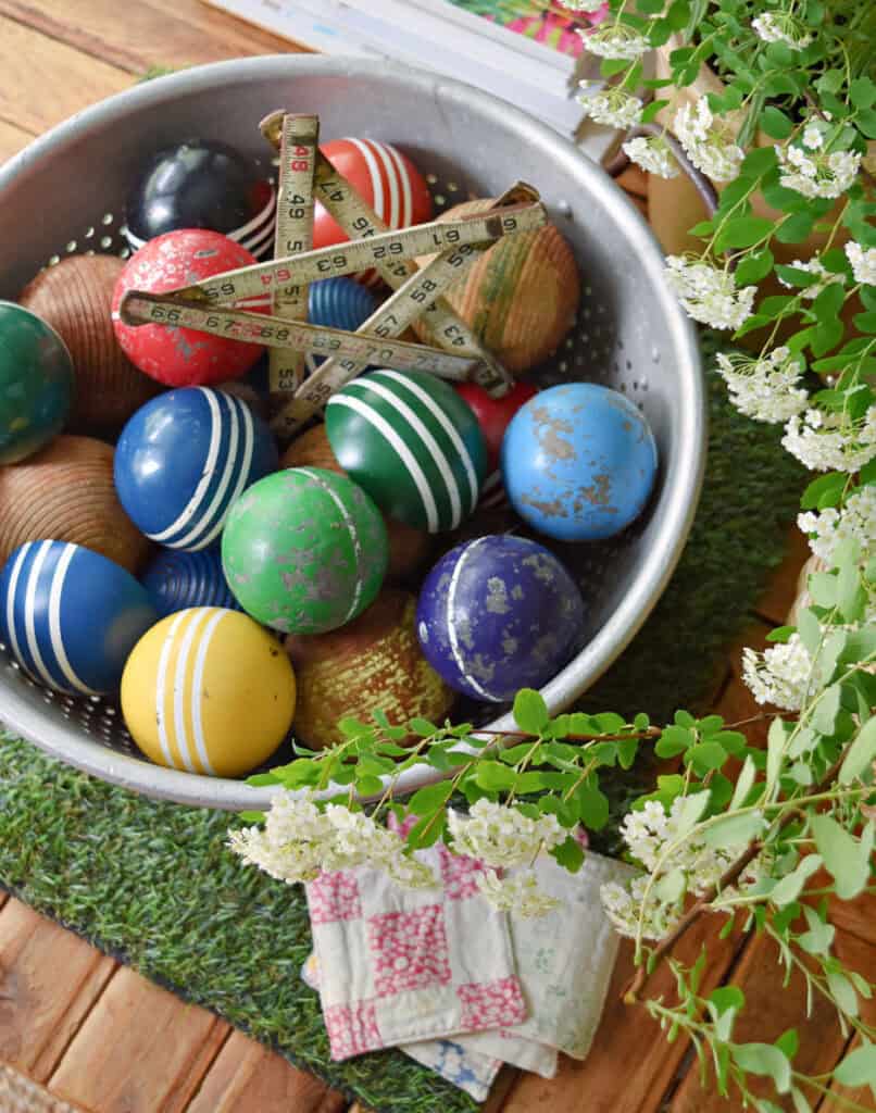 Vintage croquet balls in colander as summer decor.