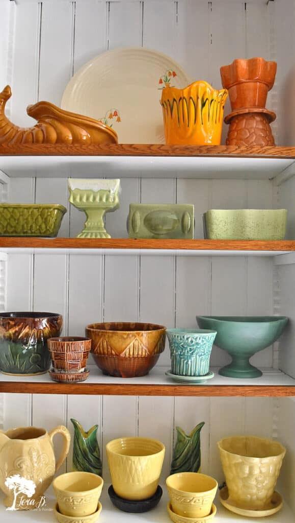 Vintage pottery collection creatively displayed by color.