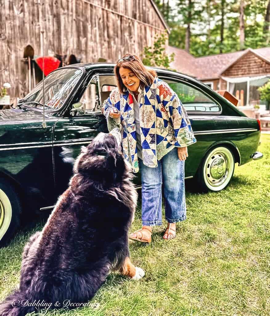 Vintage quilt jacket on woman by antique car.