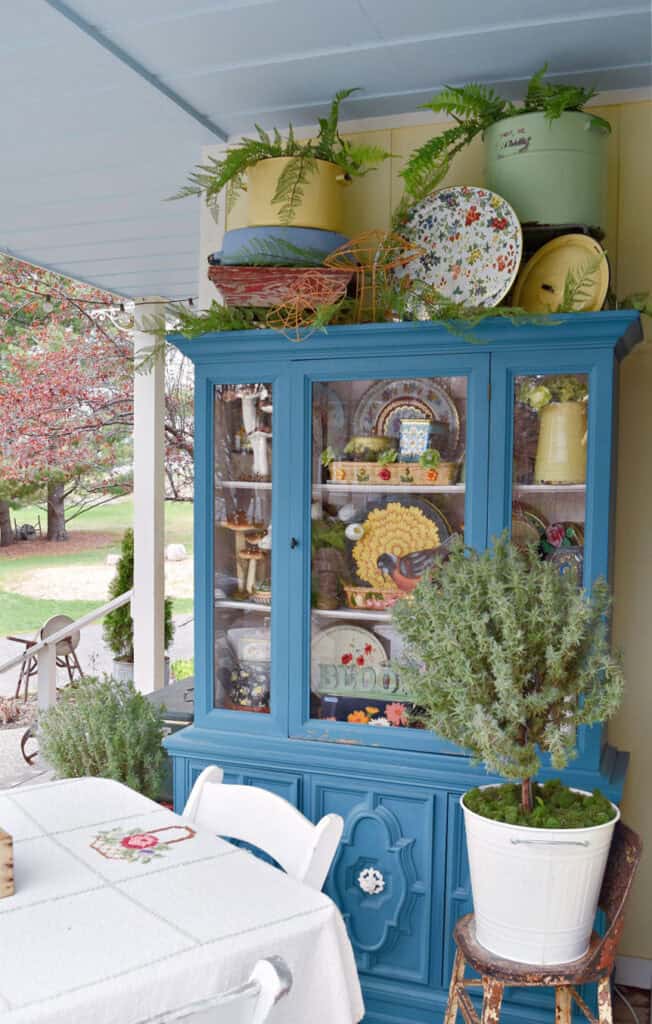 Aqua cupboard on porch with pretty display.