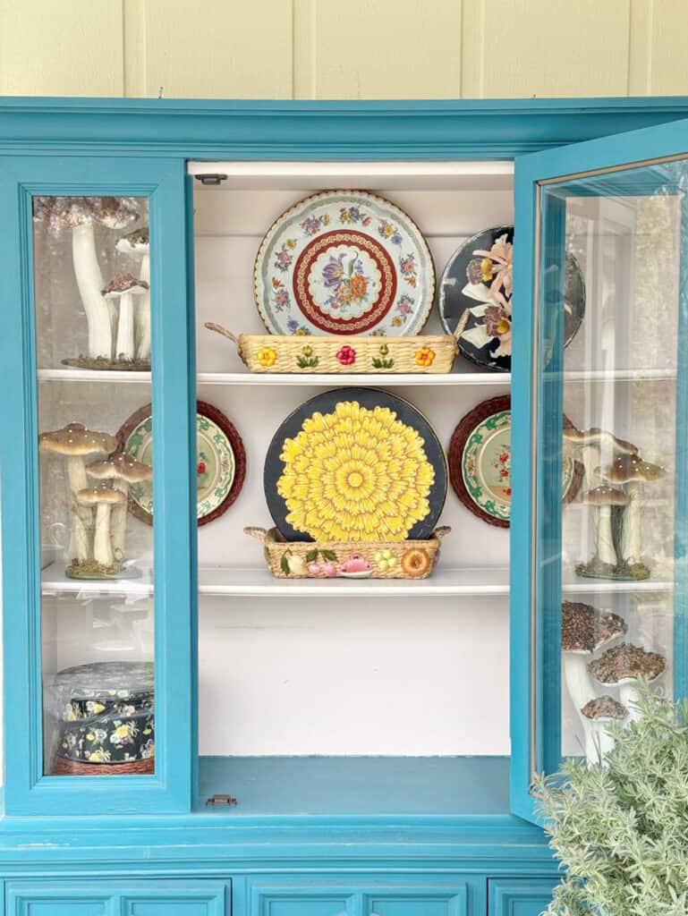 Decorating a hutch with floral tins.