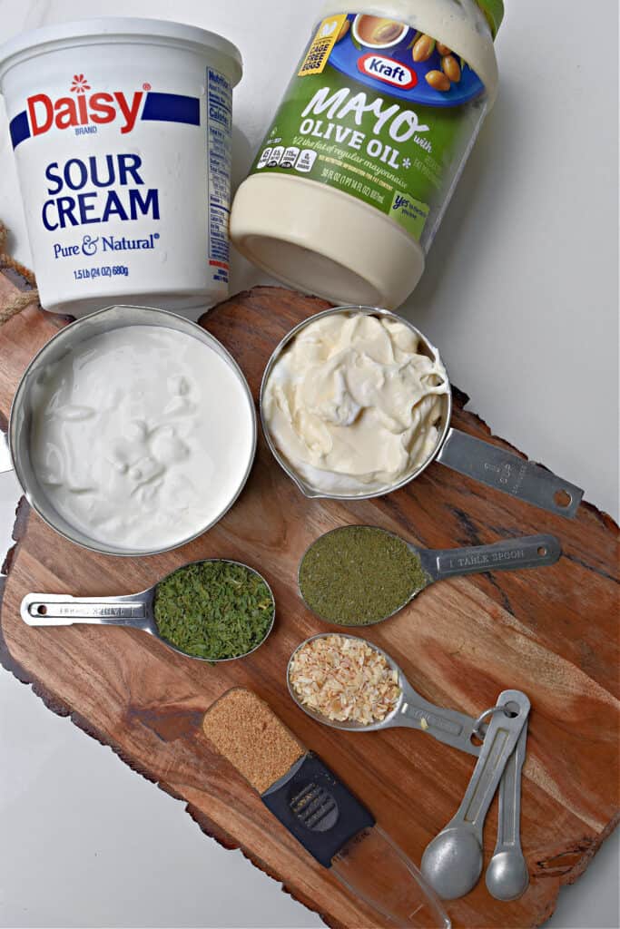 Ingredients for homemade dill dip on wood board.