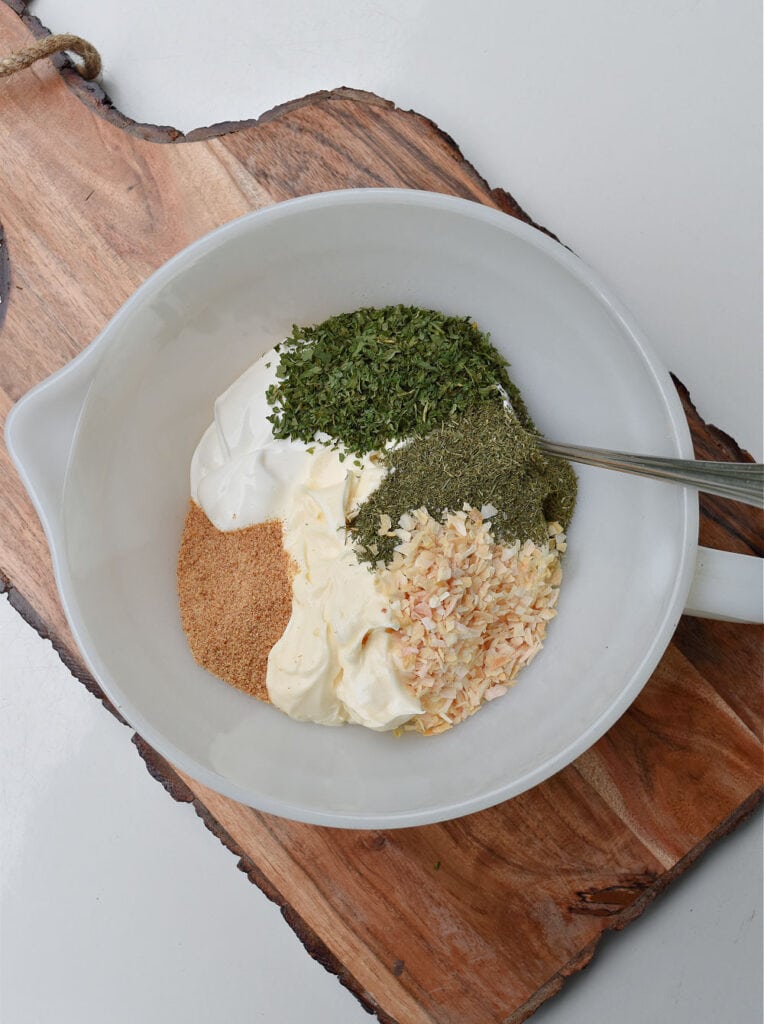 Homemade dill dip ingredients in white pyrex bowl.