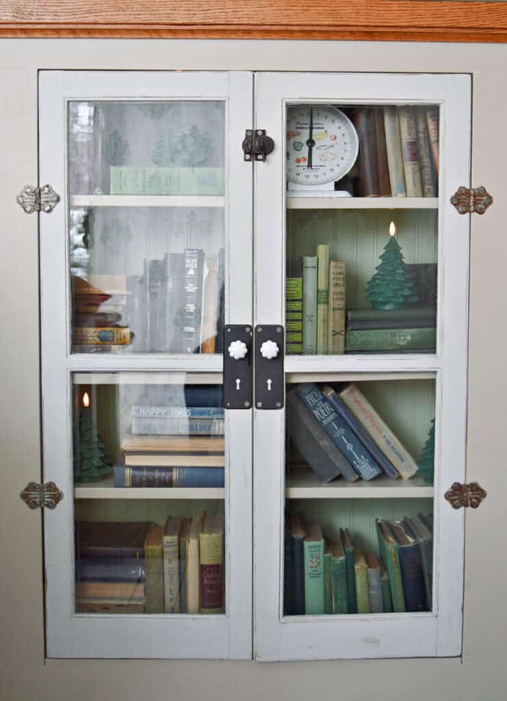 Old books on bookshelf with vintage windows.