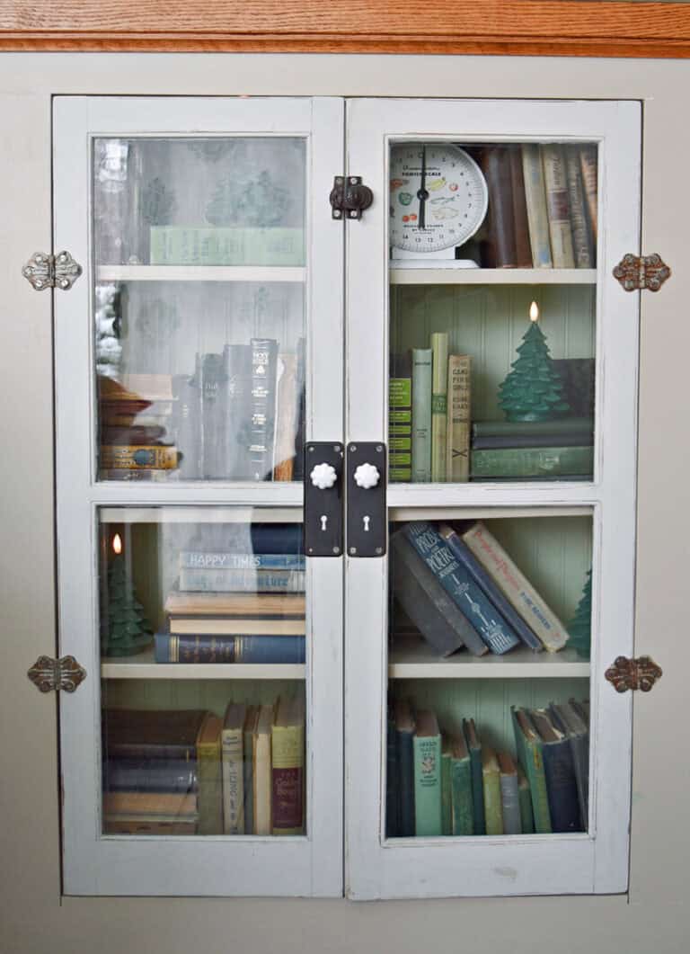 Old books on bookshelf with vintage windows.