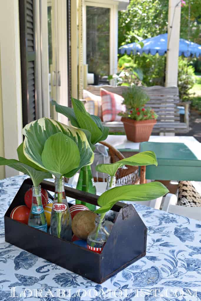 Colorful summer centerpiece with soda pop bottles and croquet balls.