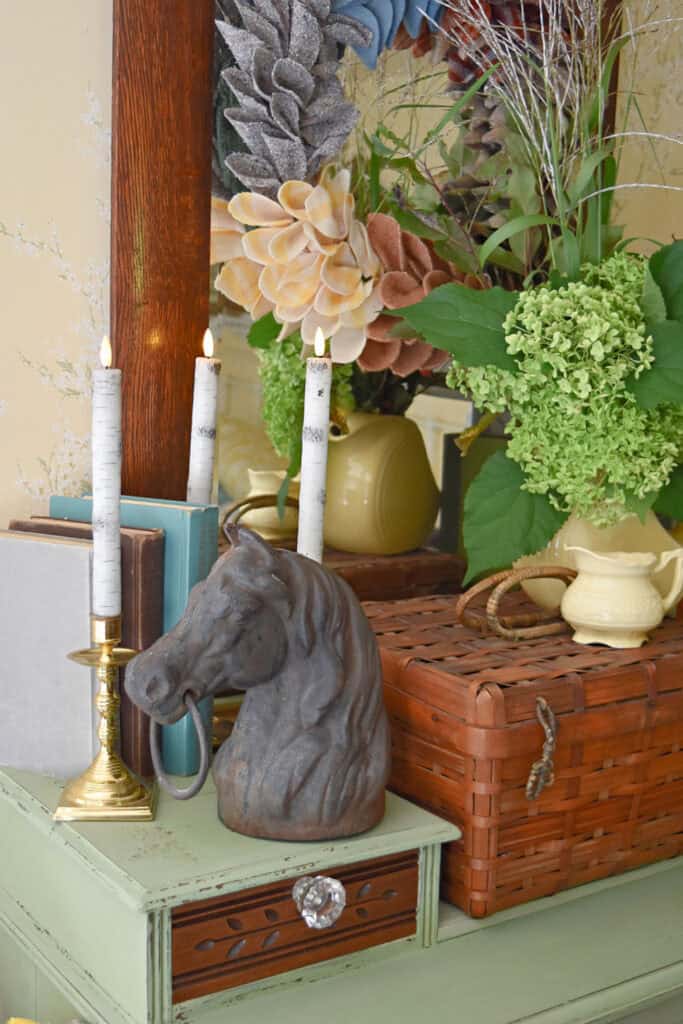 Iron horse head in fall vignette on dresser.