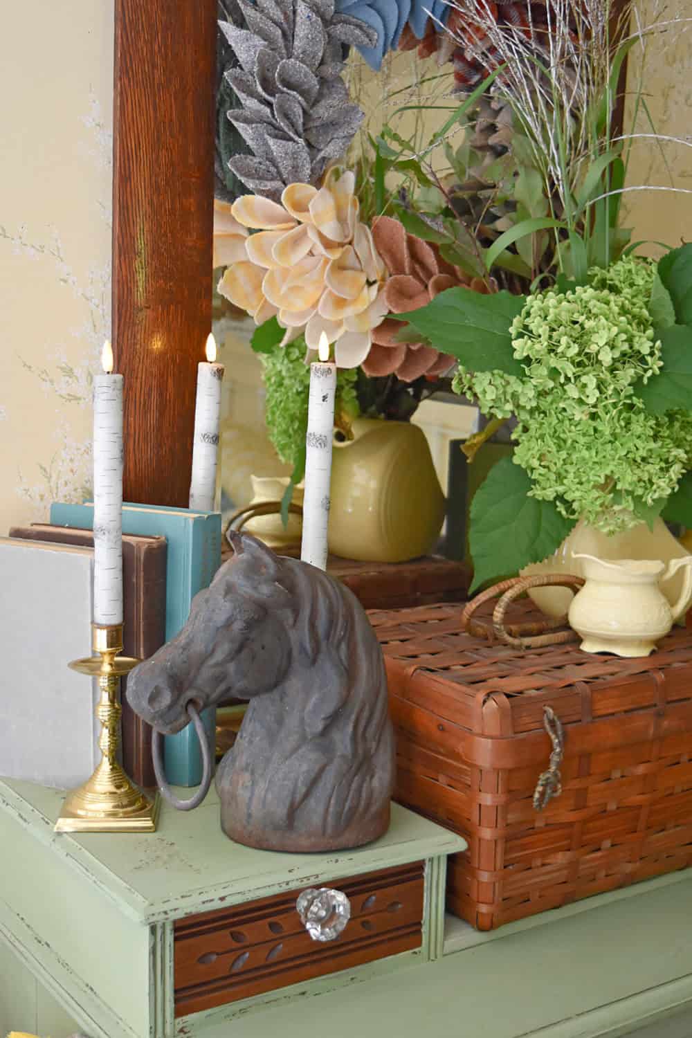 Iron horse head in fall vignette on dresser.