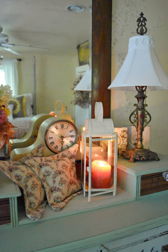 Orange candle in lantern in fall decorated bedroom.