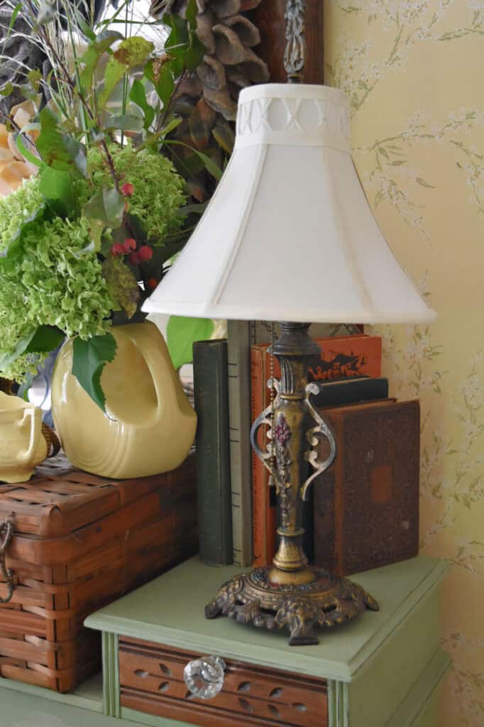 Antique brass lamp on dresser with books.