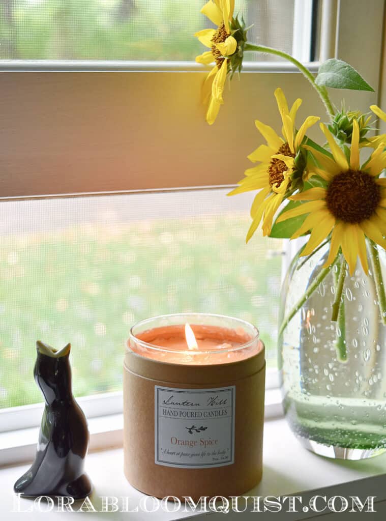 Sunflowers and candle on windowsill.