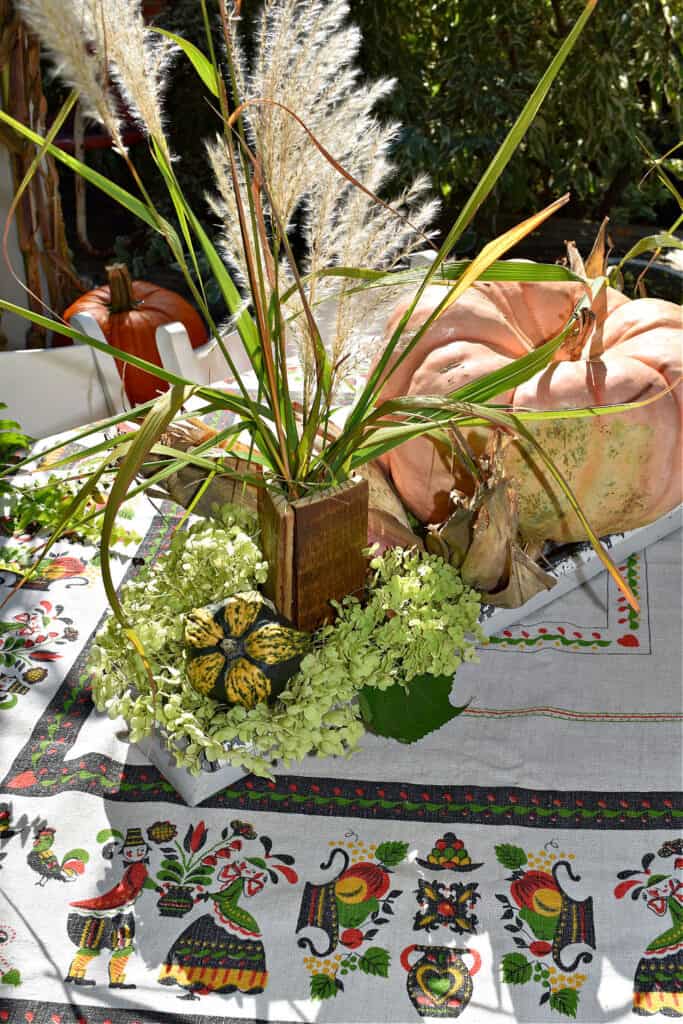 Grasses and pumpkin as Fall porch decor centerpiece.