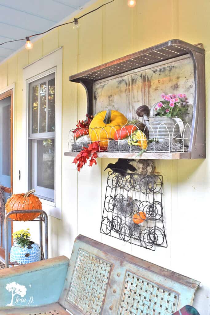 Repurposed vintage stovetop shelf decorated on a Fall porch.