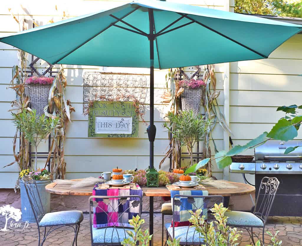 Vintage quilts set a table of vintage dishes on this Fall decorated porch and patio tour.