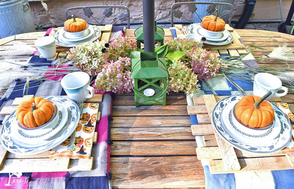 Vintage dishes set a table on a Fall decorated Porch and Patio with Salvaged Style