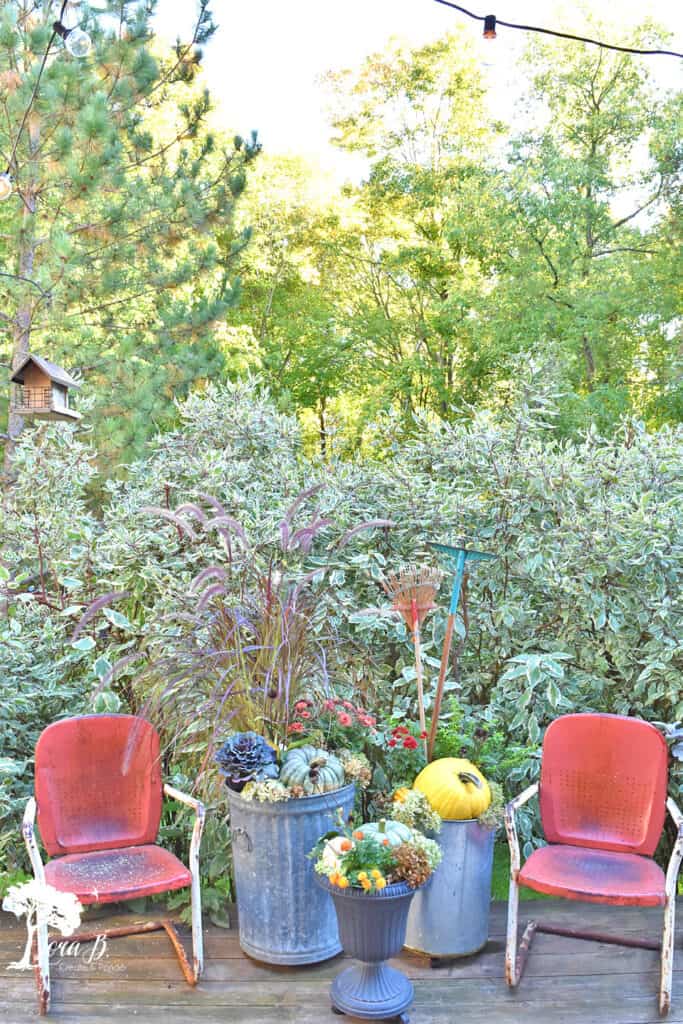 Vintage metal lawn chairs on a Fall decorated porch and patio with salvaged style.