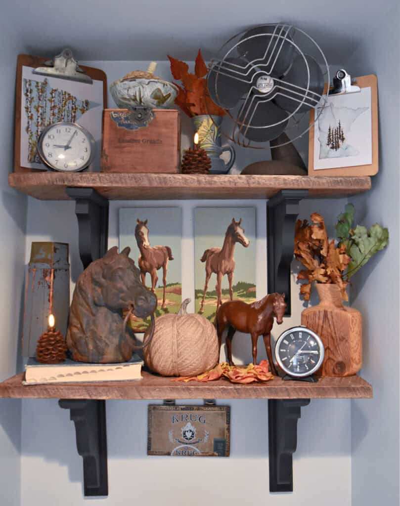 Horse theme decor on bathroom shelves.