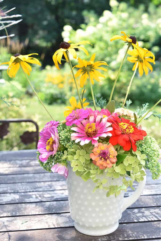 Garden flowers in white hobnail milk glass pitcher.