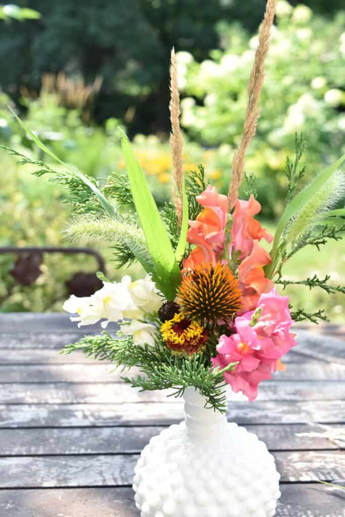 Flower arrangement in milk glass vase.