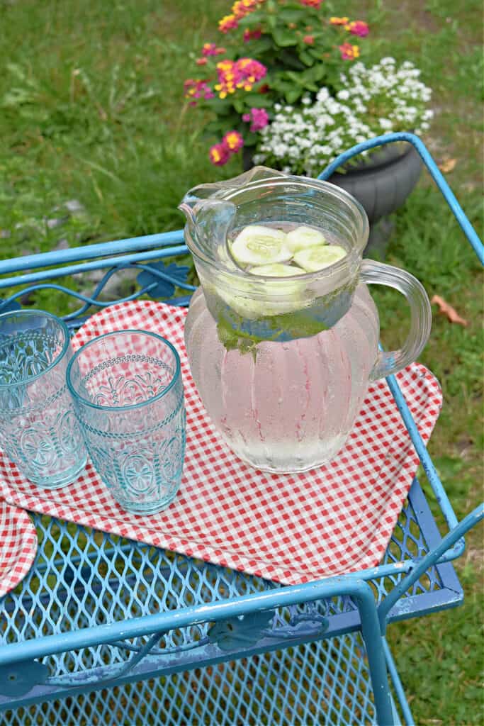Glass pitcher with cucumber mint water.