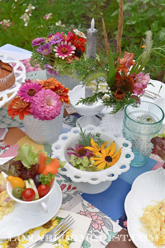 Colorful garden party table setting with milk glass and zinnas.