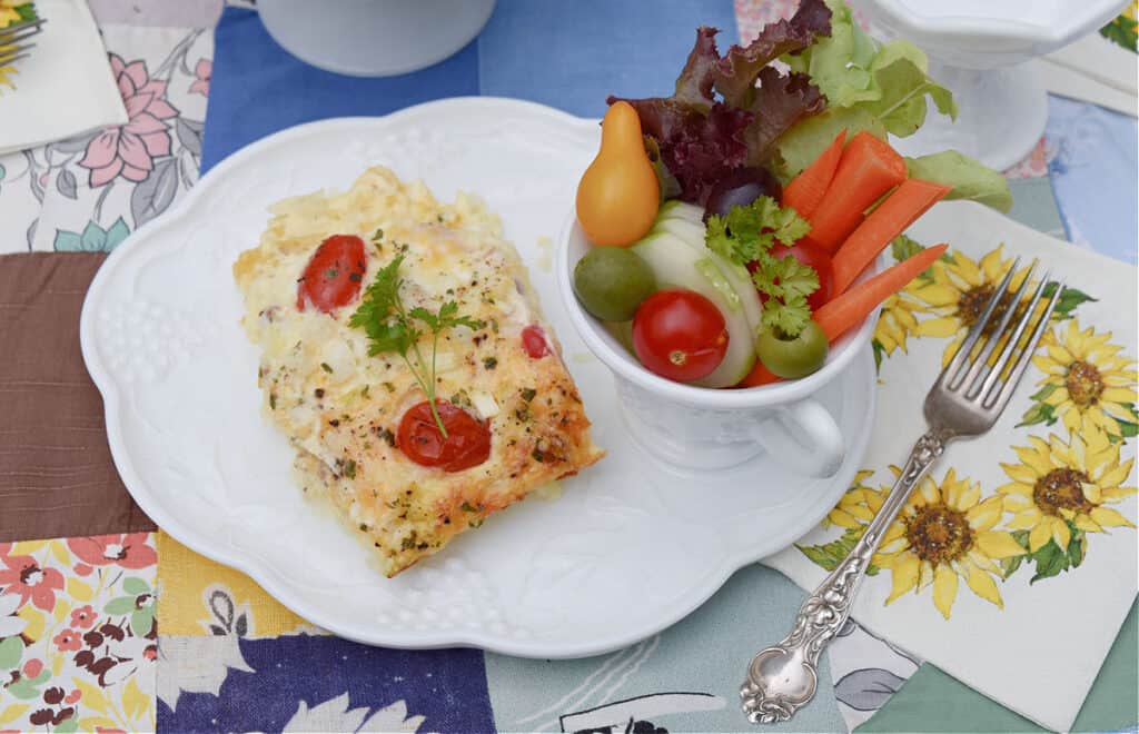 Egg dish and fresh vegetables on milk glass luncheon set.