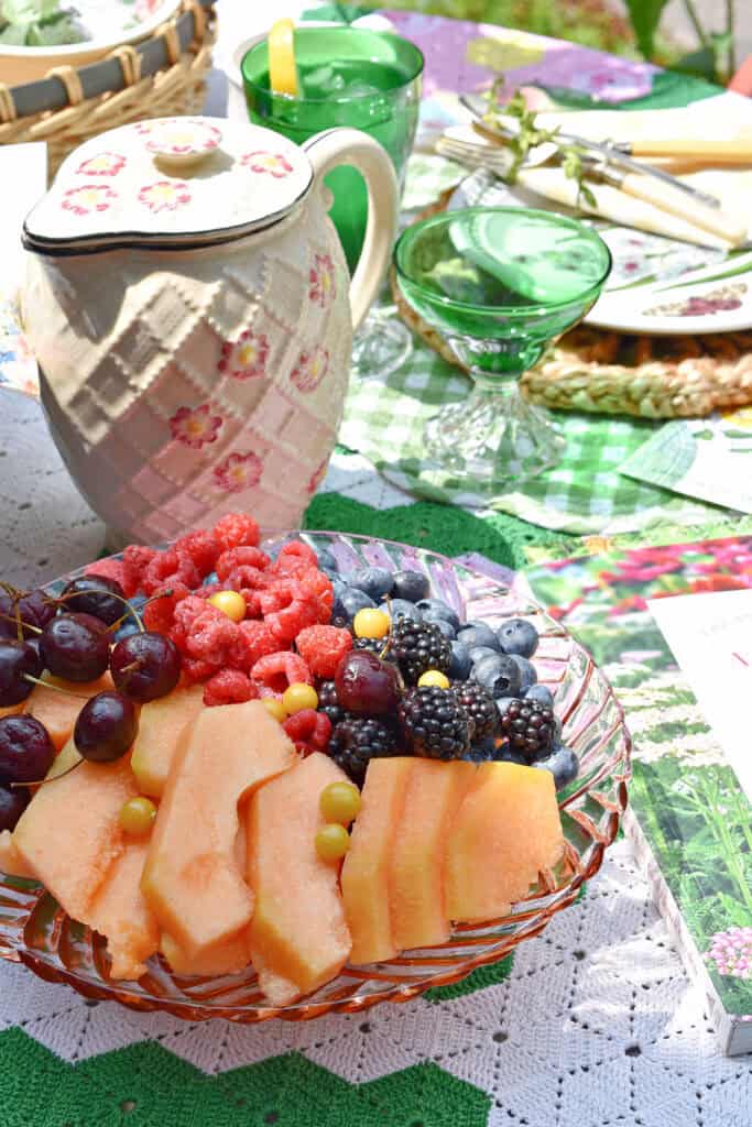 Colorful summer fruit on pink platter.