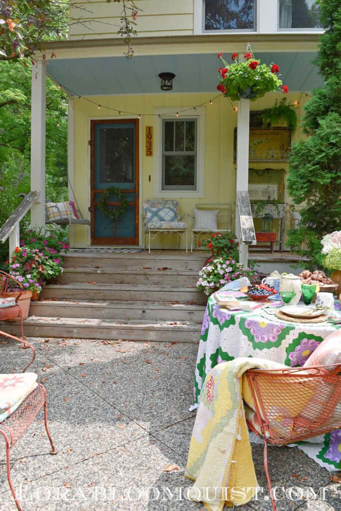 Pretty garden party table setting by farmhouse porch.