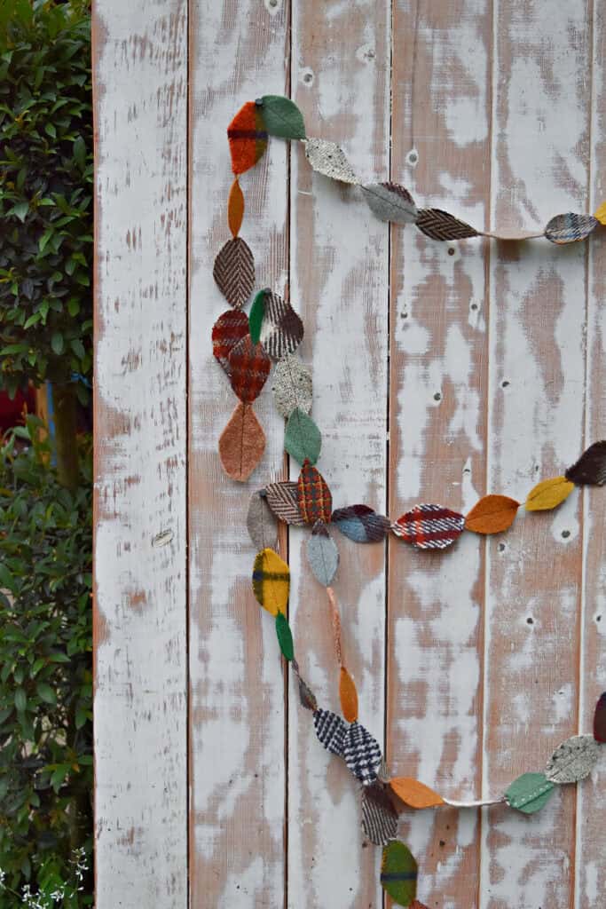 DIY upcycled scrap fabric leaf garland on white chippy door.