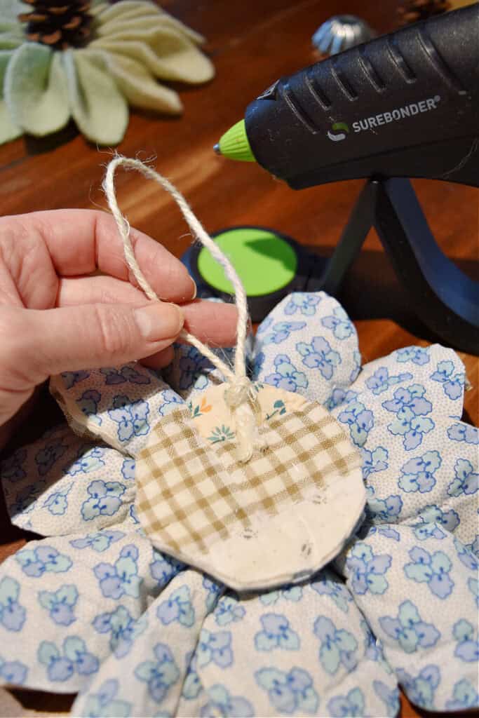 Gluing twine loop on scrap fabric ornament.