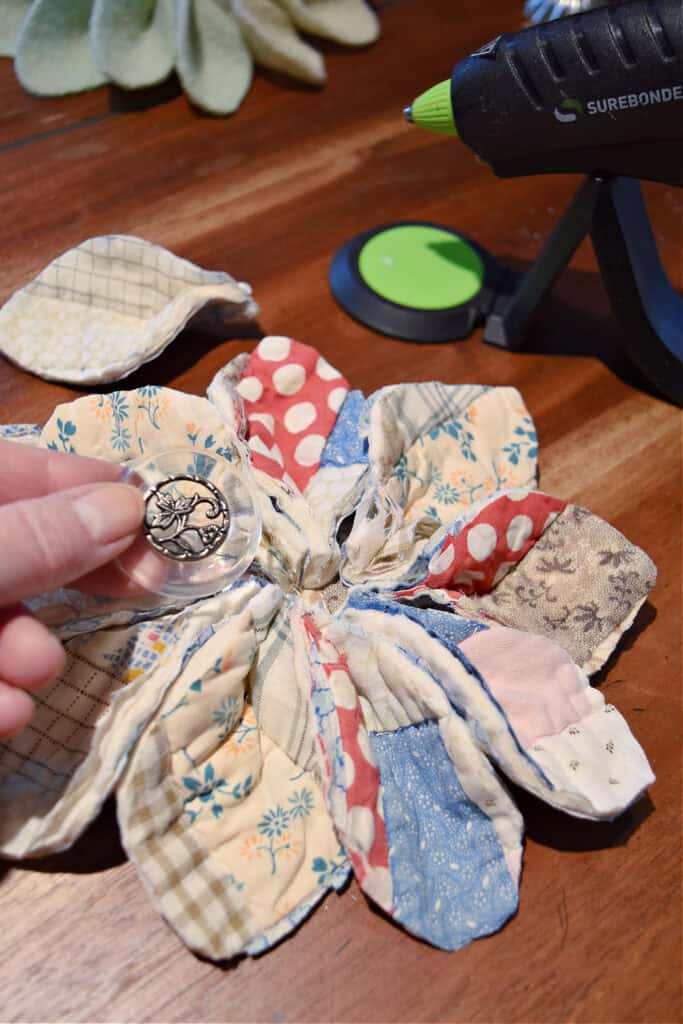 Gluing old button onto scrap fabric gift topper.