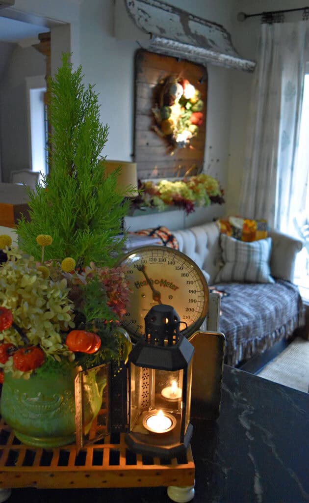 Fall foliage joins a vintage scale and a lantern in an autumn decorated kitchen.