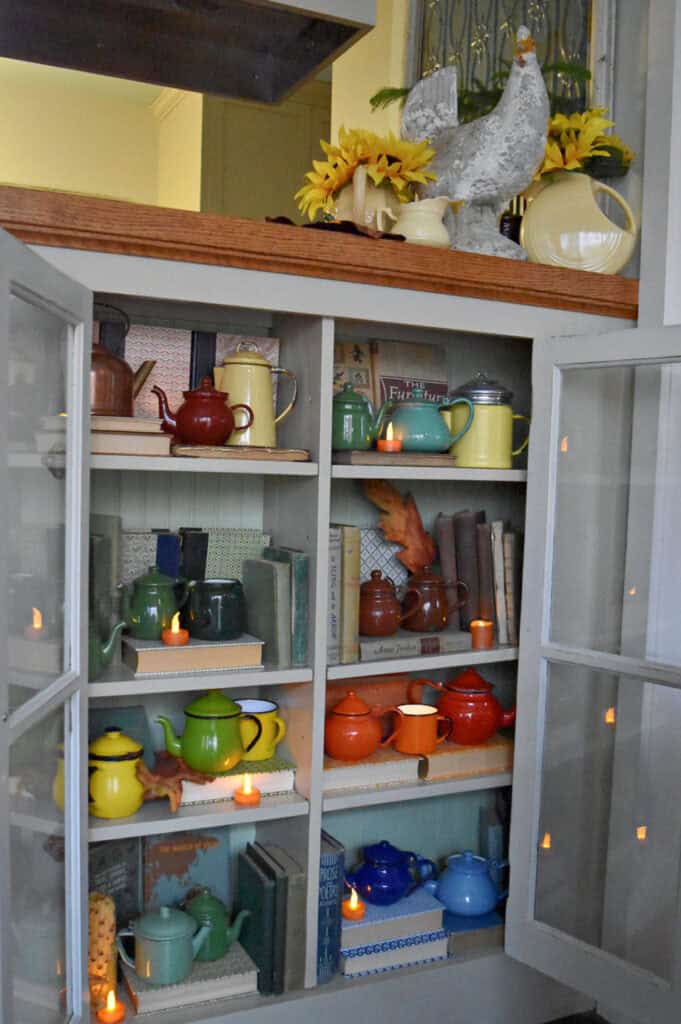 Vintage enamelware teapot collection in cupboard display for Fall.